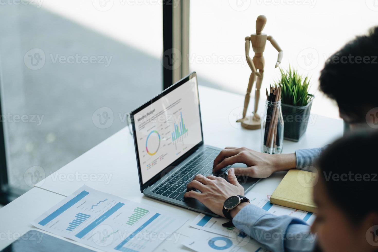 Geschäftsmann arbeitet mit Laptop im Büro und tippt auf der Tastatur. Diagrammdiagramm für Finanzunterlagen auf dem Schreibtisch foto