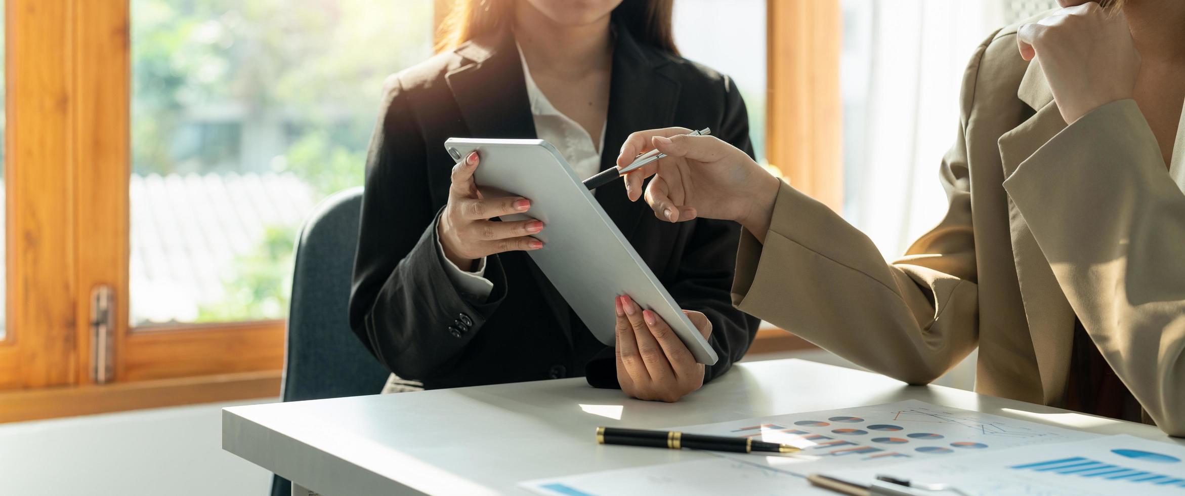 zwei partner geschäftsmann investor sprechen über finanzstatistik diagramminformationen in mobilen tabletten zusammen sitzen im besprechungsraum im büro, finanzen, investitionen und digitaltechnologiekonzept foto