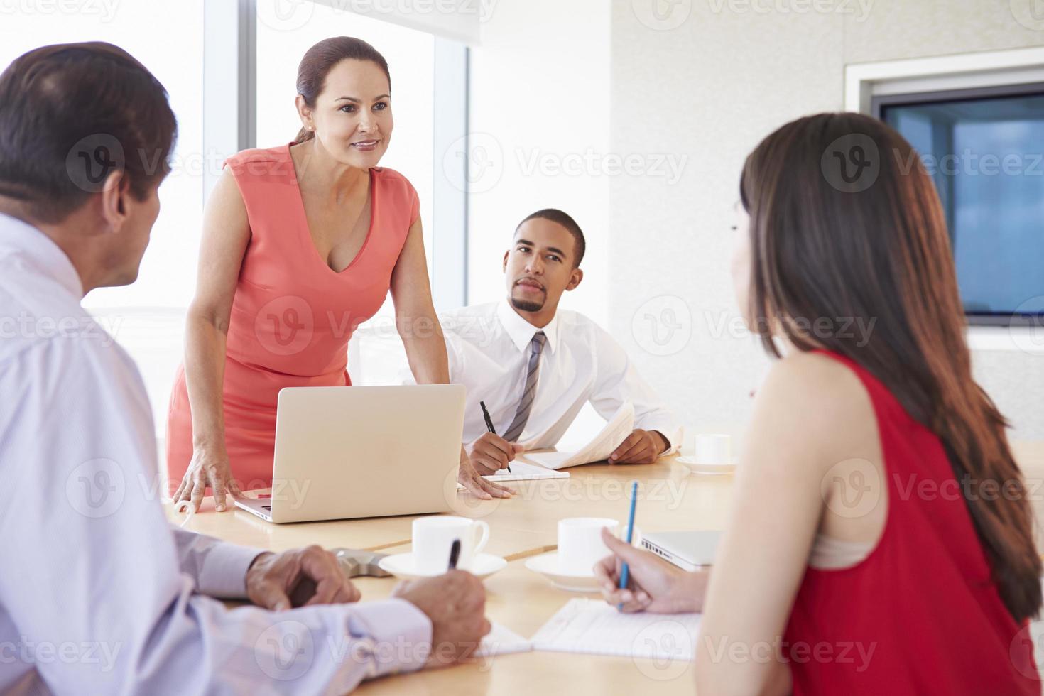 Vier Geschäftsleute treffen sich im Sitzungssaal foto