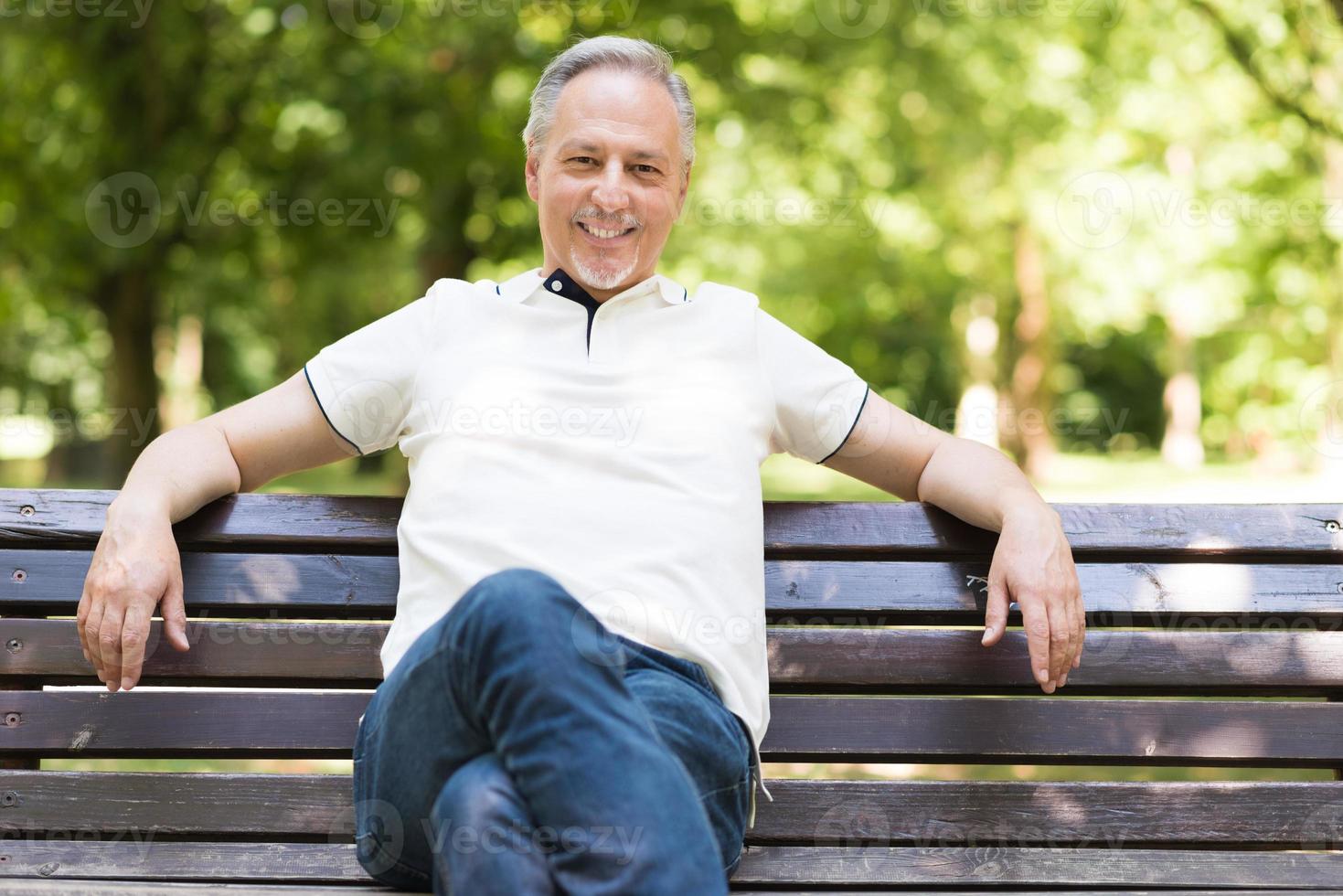 reifer Mann, der sich in einem Park entspannt foto
