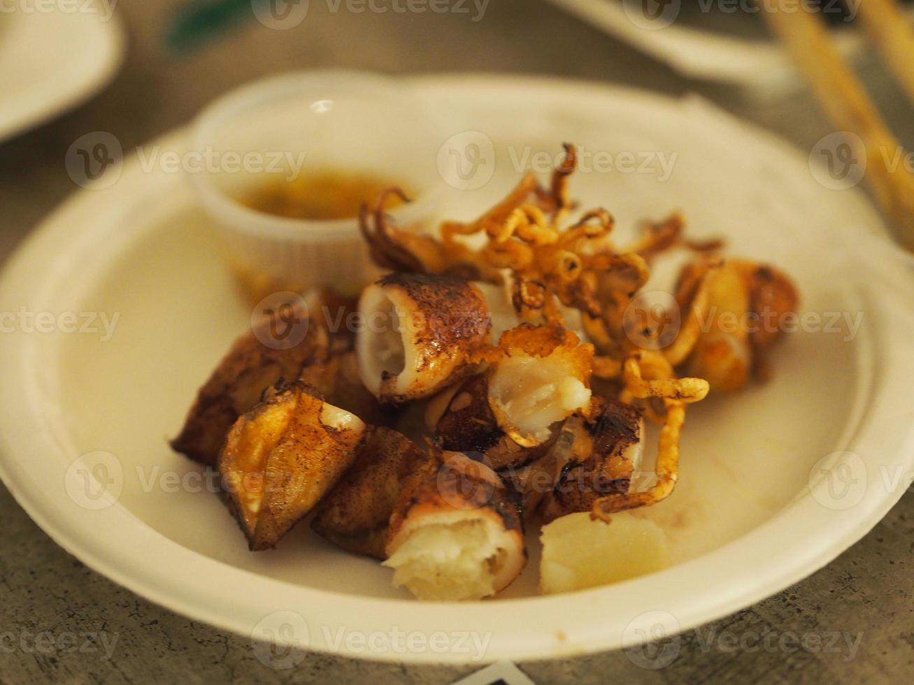 gegrilltes tintenfischei mit saucenscheibe in weißer platte, meeresfrüchte foto