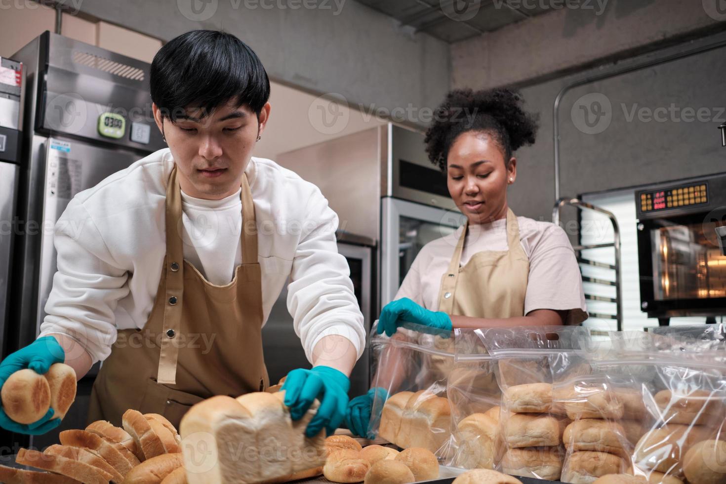 Zwei junge Freunde und Startup-Partner von Brotteig und Gebäck, die mit hausgemachten Backarbeiten beschäftigt sind, während sie täglich Bestellungen kochen, verpacken und an Bäckereien liefern, Kleinunternehmer. foto