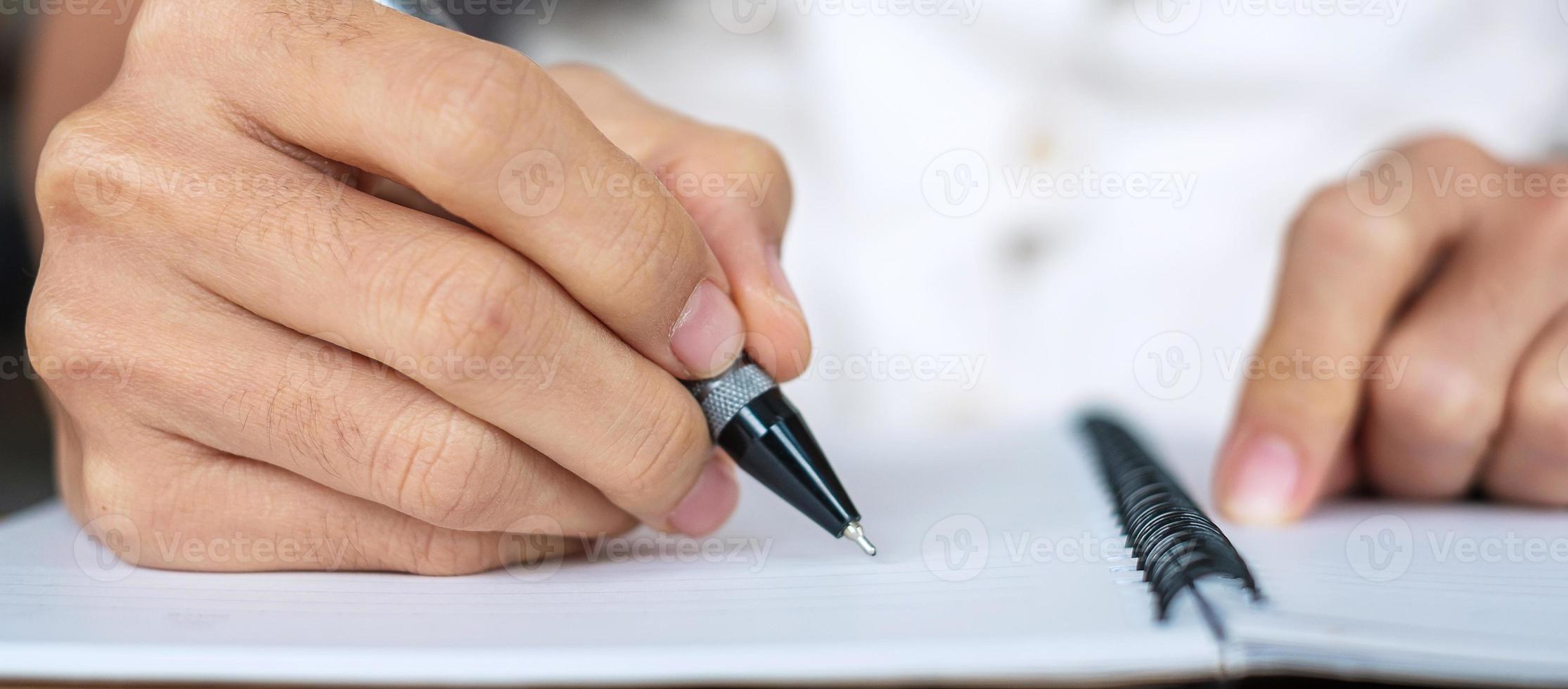 Geschäftsfrau schreibt etwas auf Notizbuch im Büro oder Café, Hand der Frau hält Stift mit Unterschrift auf Papierbericht. Geschäftskonzepte foto