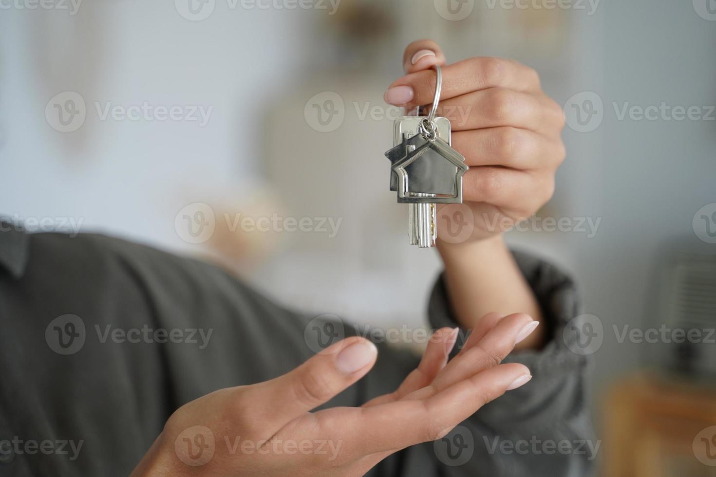weibliche immobilienmaklerin oder hausbesitzerin hält schlüssel für neues haus. Mietobjekt, Hypothek foto
