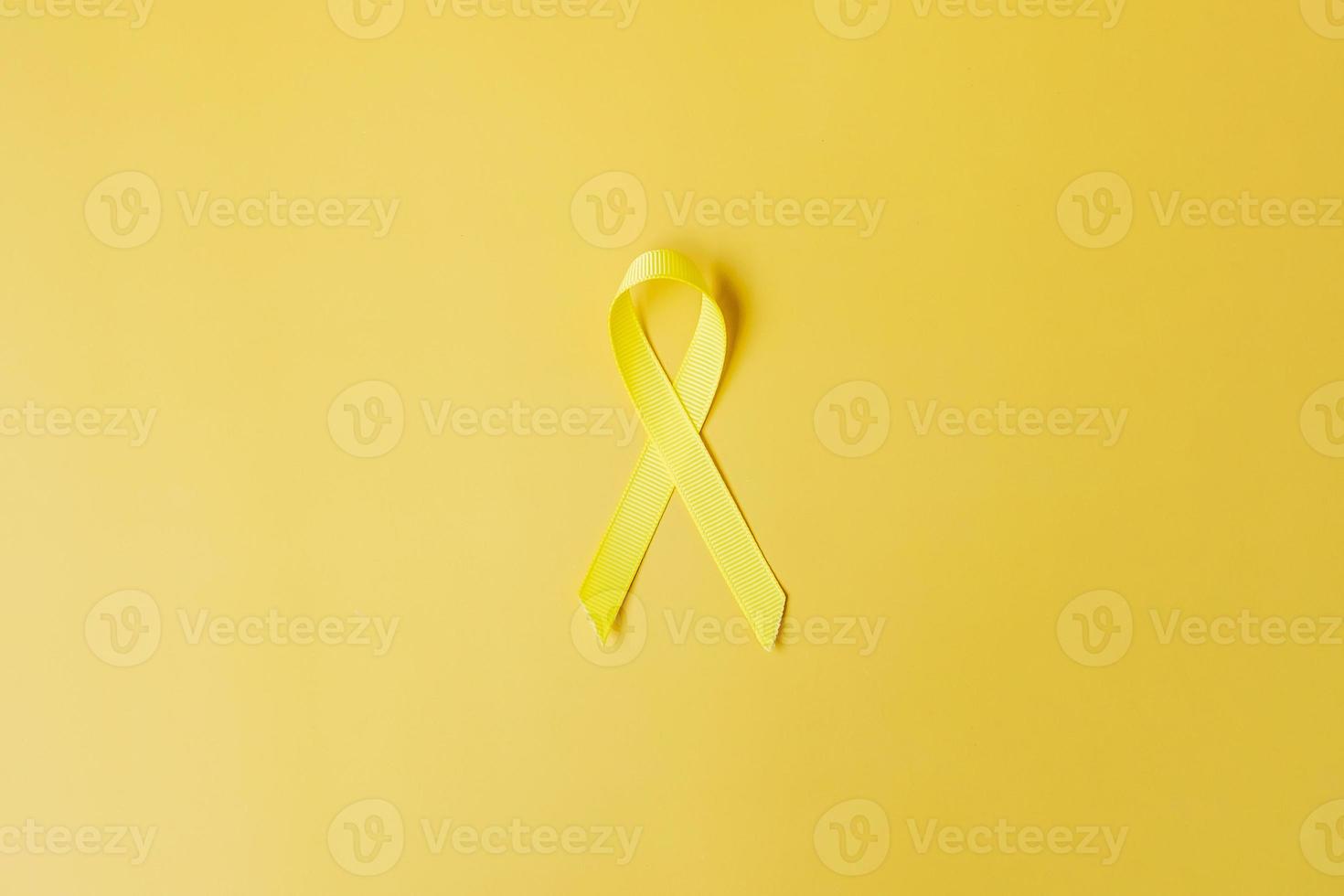 gelbes band auf gelbem hintergrund zur unterstützung von lebenden und kranken menschen. Tag der Suizidprävention im September, Monat des Bewusstseins für Krebs im Kindesalter und Konzept des Weltkrebstages foto