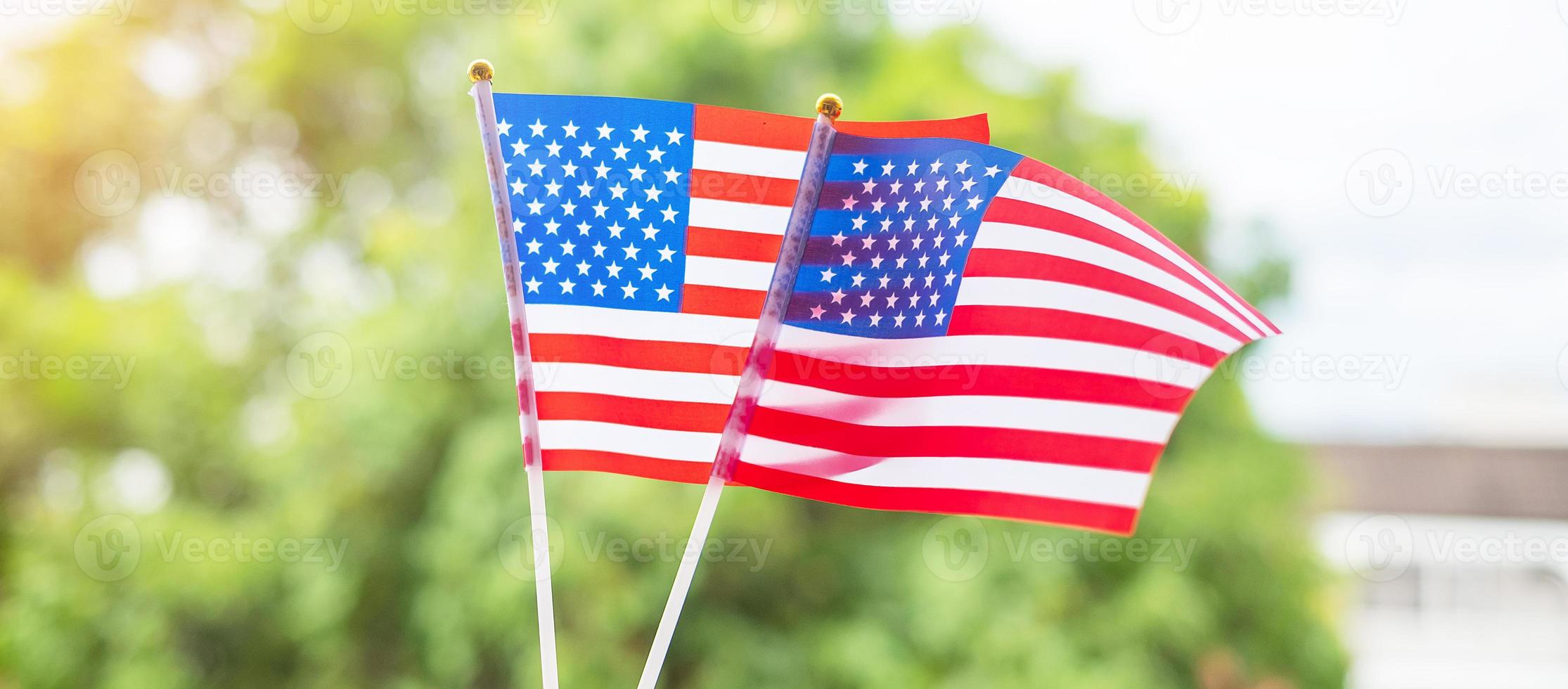 Hand, die die Flagge der Vereinigten Staaten von Amerika auf grünem Hintergrund hält. usa feiertag von veteranen, denkmal, unabhängigkeit und arbeitstagkonzept foto