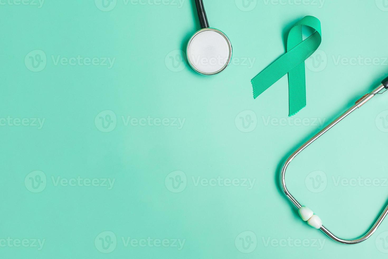 september bewusstseinsmonat für eierstockkrebs, blaugrünes band mit stethoskop zur unterstützung lebender menschen und krankheit. konzepte für das gesundheitswesen und den weltkrebstag foto
