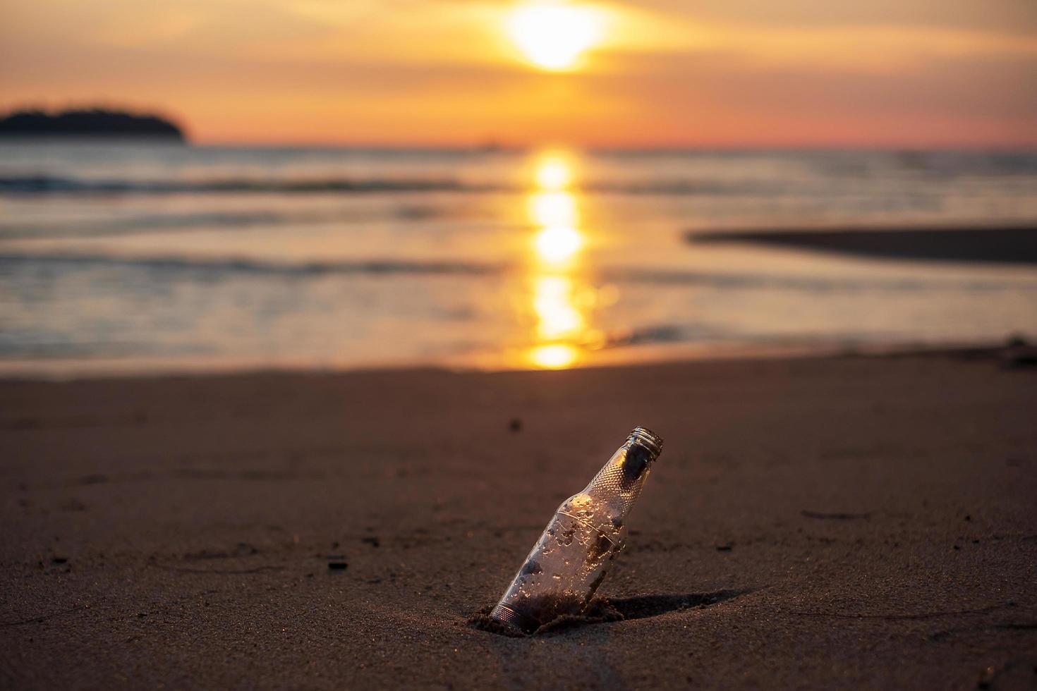 Glasflaschenmüll am Strand vor Sonnenuntergang. Ökologie, Umwelt, Umweltverschmutzung und ökologisches Problemkonzept foto