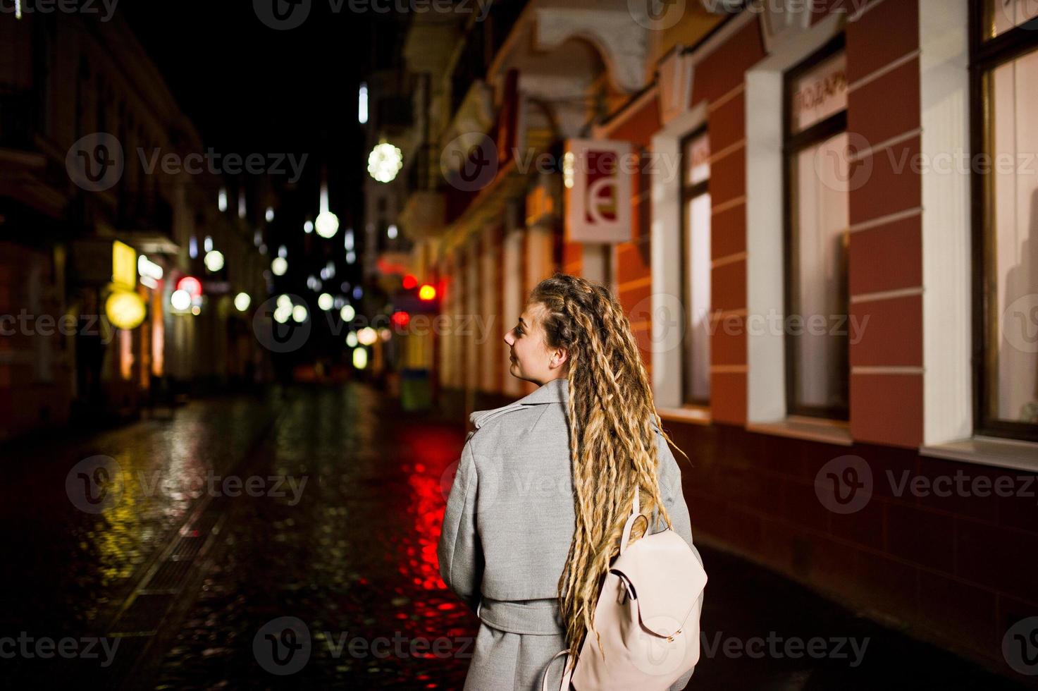 Mädchen mit Dreadlocks, die nachts auf der Straße der Stadt spazieren gehen. foto