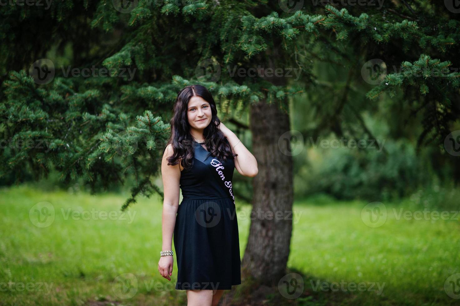 Porträt eines wunderschönen Mädchens, das beim Junggesellinnenabschied auf Schwarz trägt und im Park posiert. foto