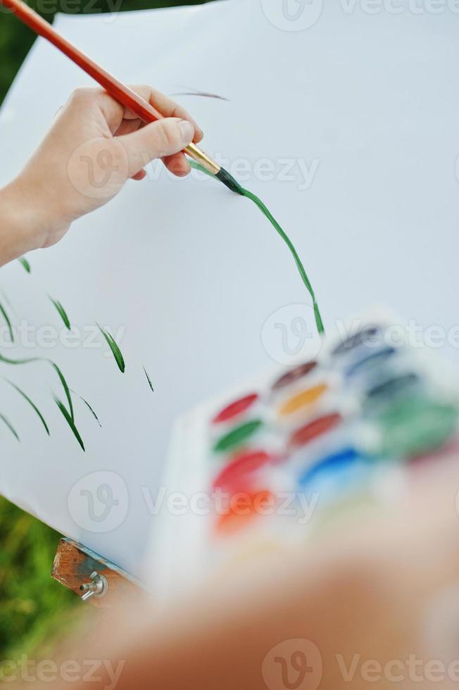 Nahaufnahmefoto der weiblichen Handmalerei auf dem Papier mit Aquarellen. foto