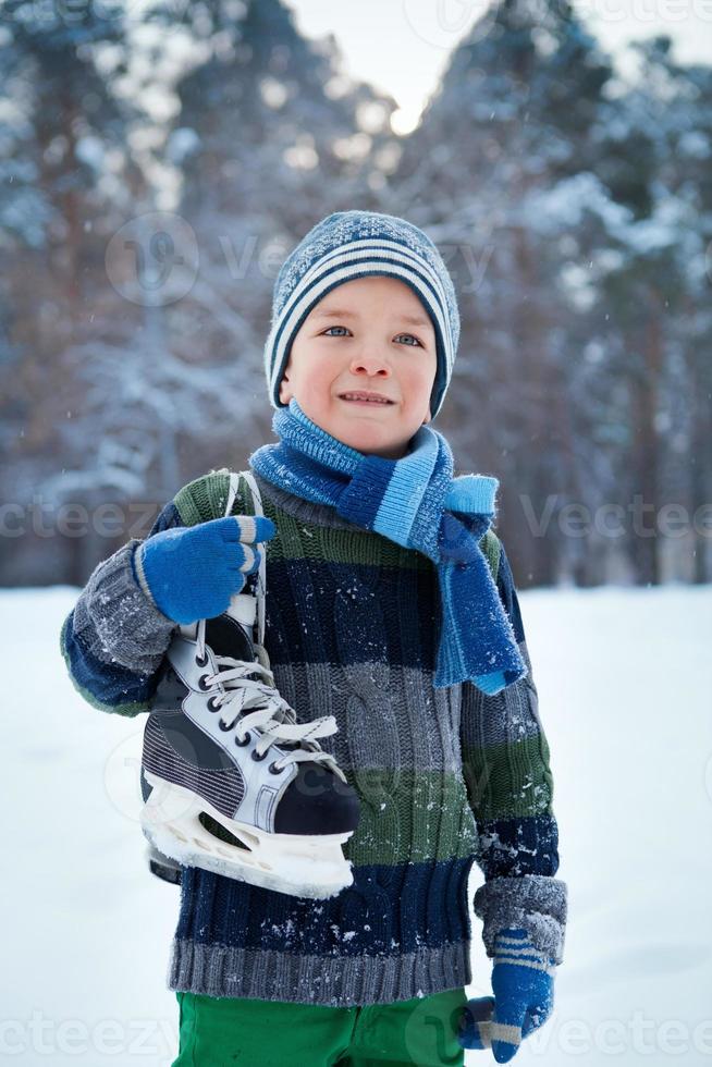 Porträt eines Jungen mit Schlittschuhen, Winter foto