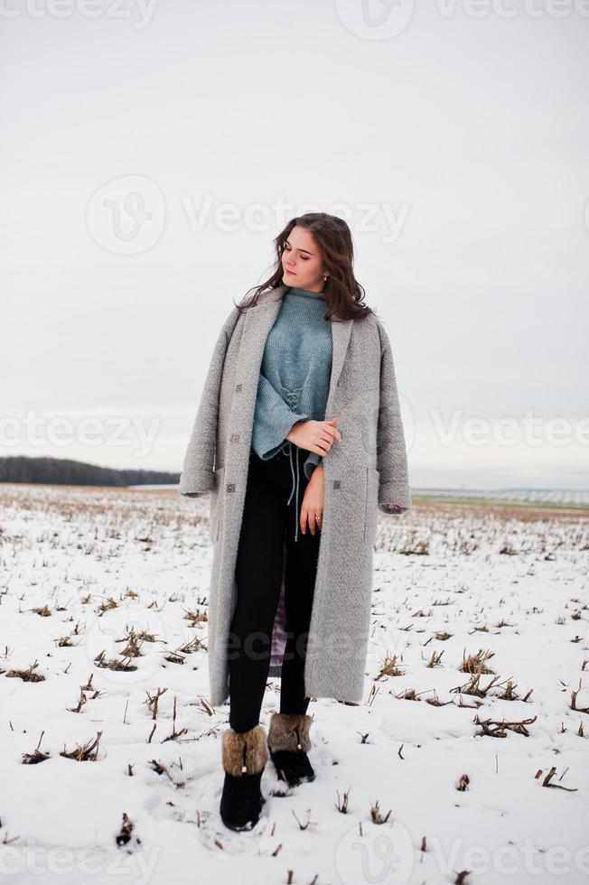 sanftes Mädchen im grauen Mantel gegen Schneelandschaft. foto