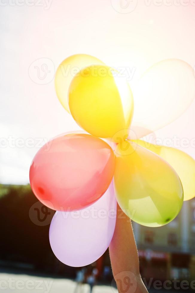 Luftballons zur Hand des Mädchens am sonnigen Tag. foto