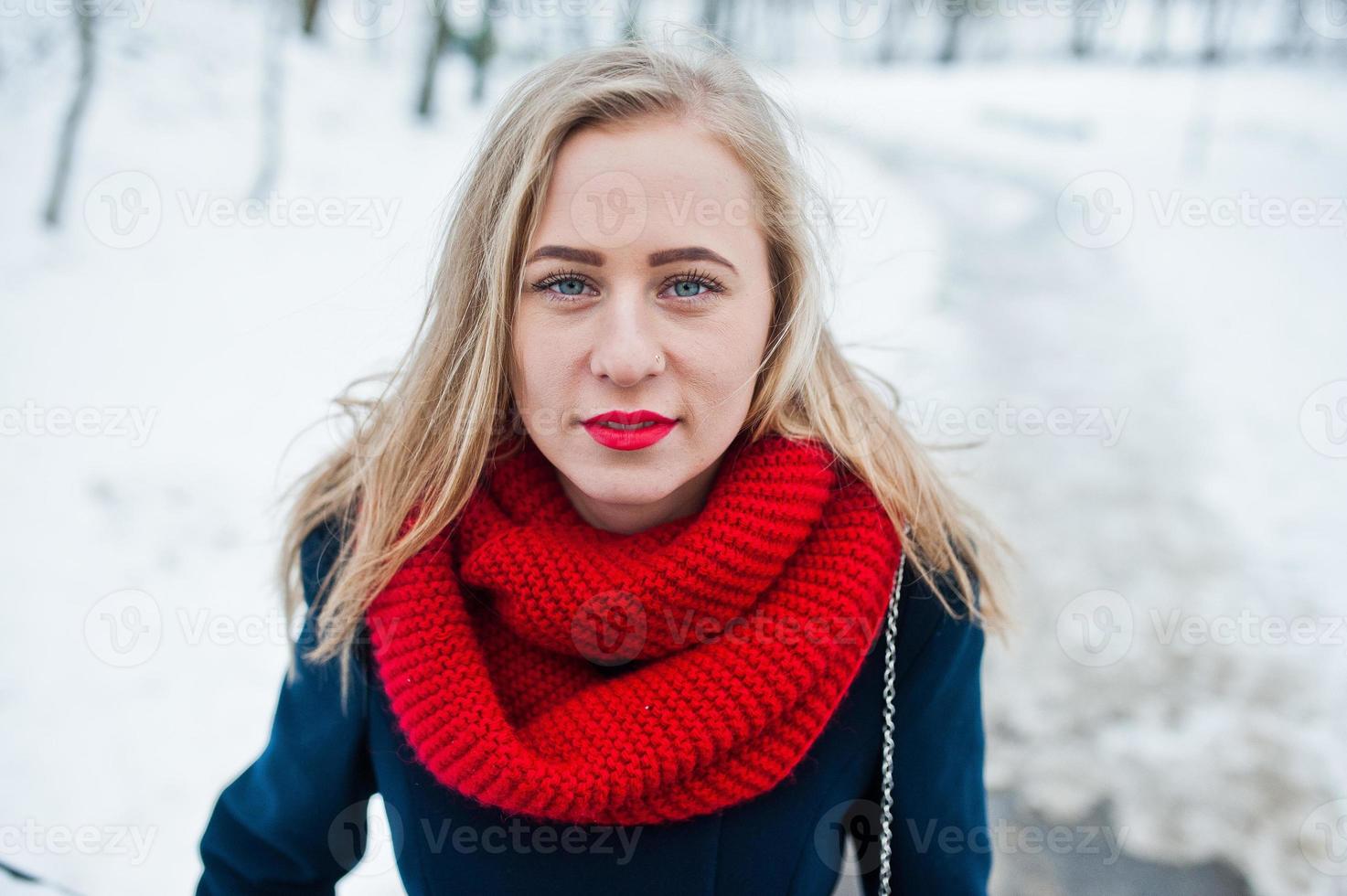 Porträt eines blonden Mädchens in rotem Schal und Mantel am Wintertag. foto