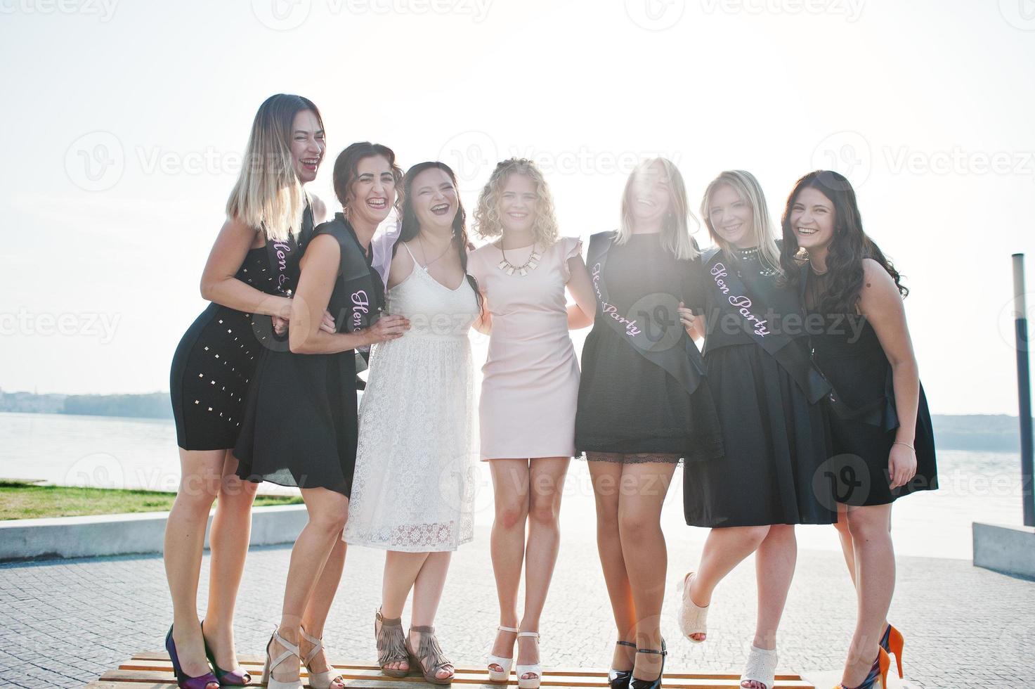 Gruppe von 7 Mädchen in Schwarz und 2 Bräute beim Junggesellinnenabschied. foto
