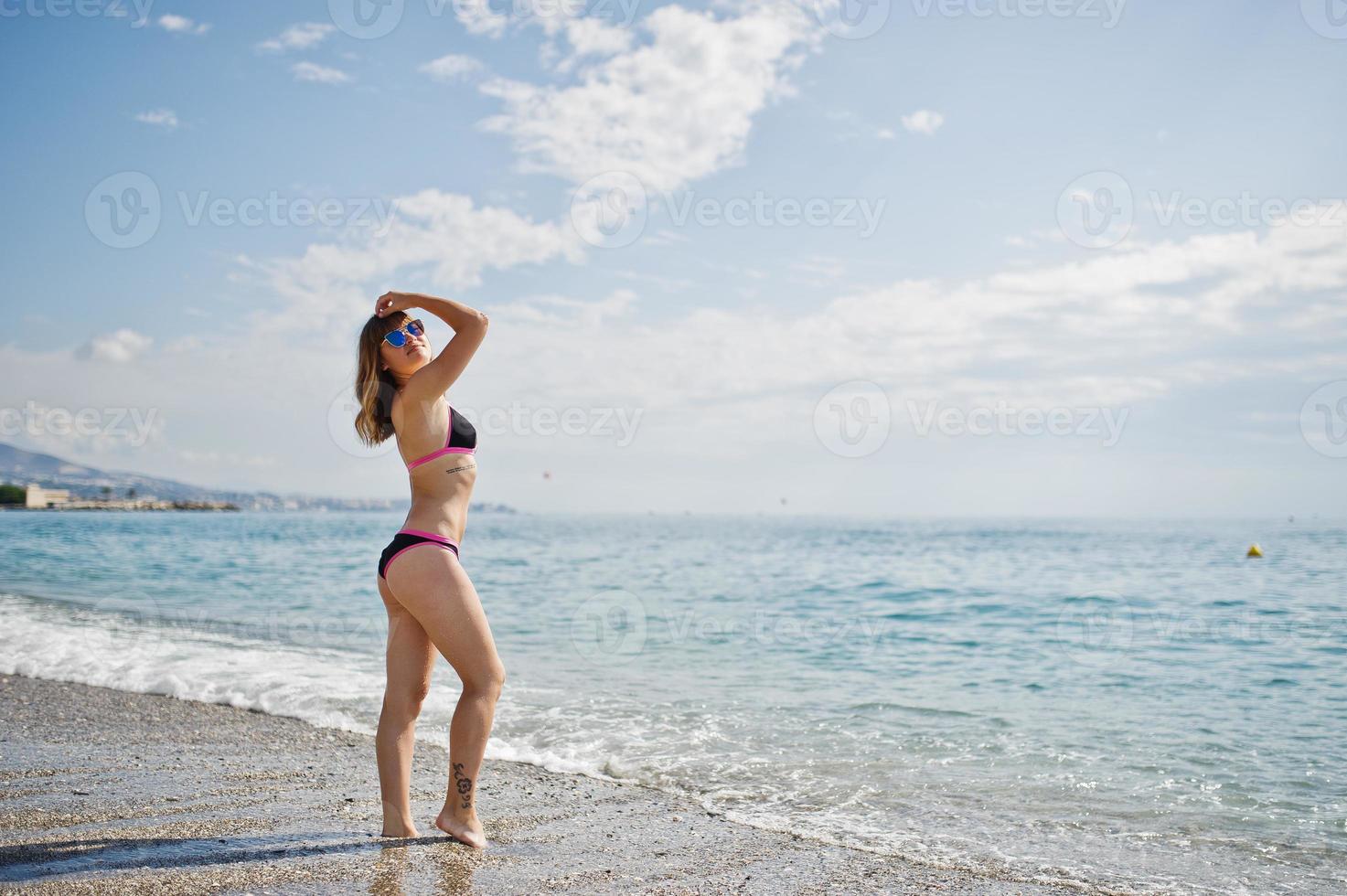 schönes Modell, das sich an einem Strand in einem Badeanzug entspannt. foto