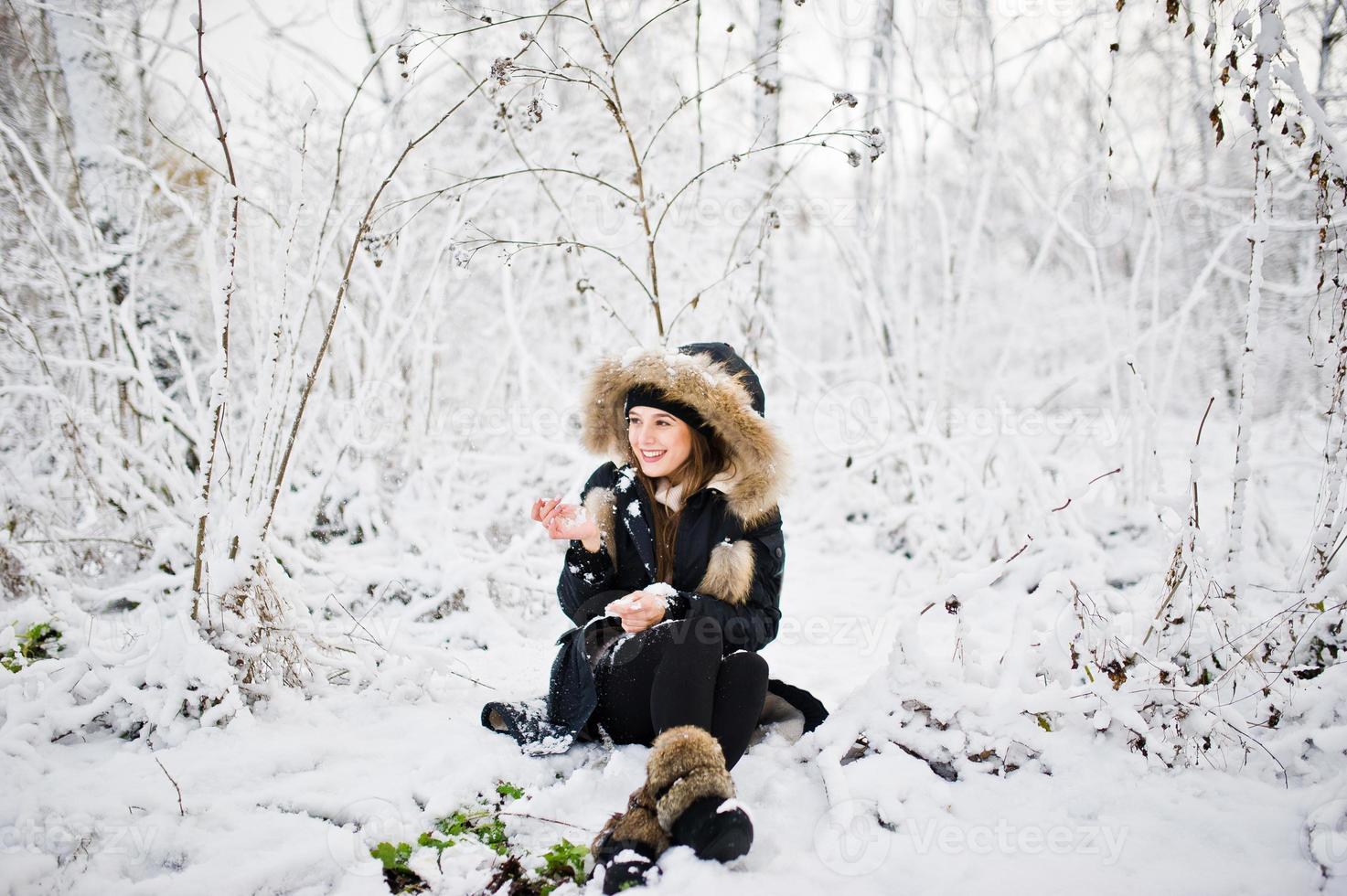 schönes brünettes Mädchen in warmer Winterkleidung. Modell auf Winterjacke und schwarzem Hut. foto