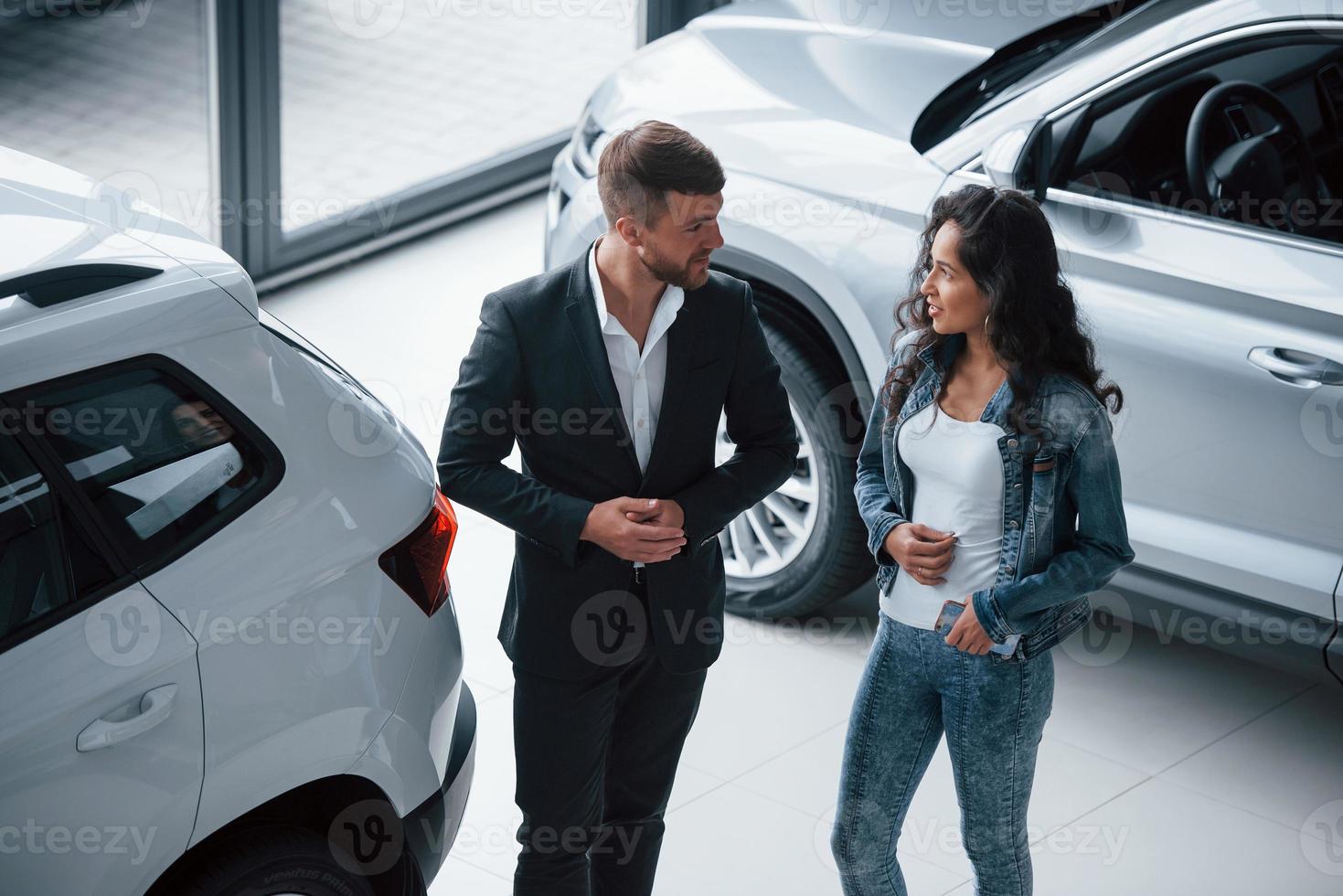 aufmerksam zuhören. Kundin und moderner stylischer bärtiger Geschäftsmann im Autosalon foto