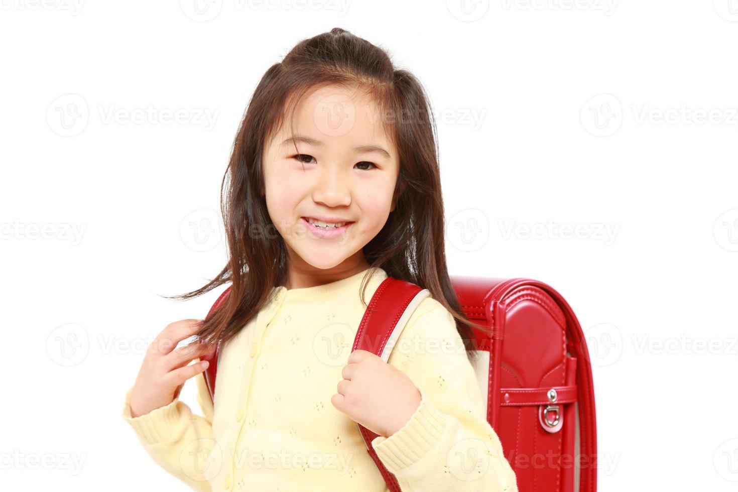 japanisches Schulmädchen mit rotem Schulranzenlächeln foto