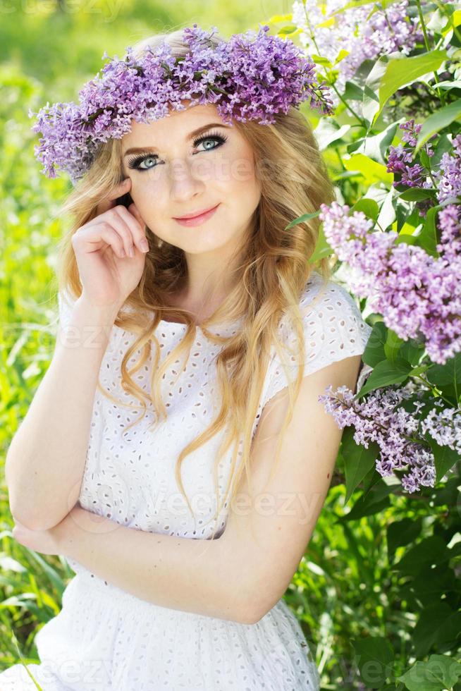 Porträt des schönen Mädchens mit Kranz aus lila Blumen foto