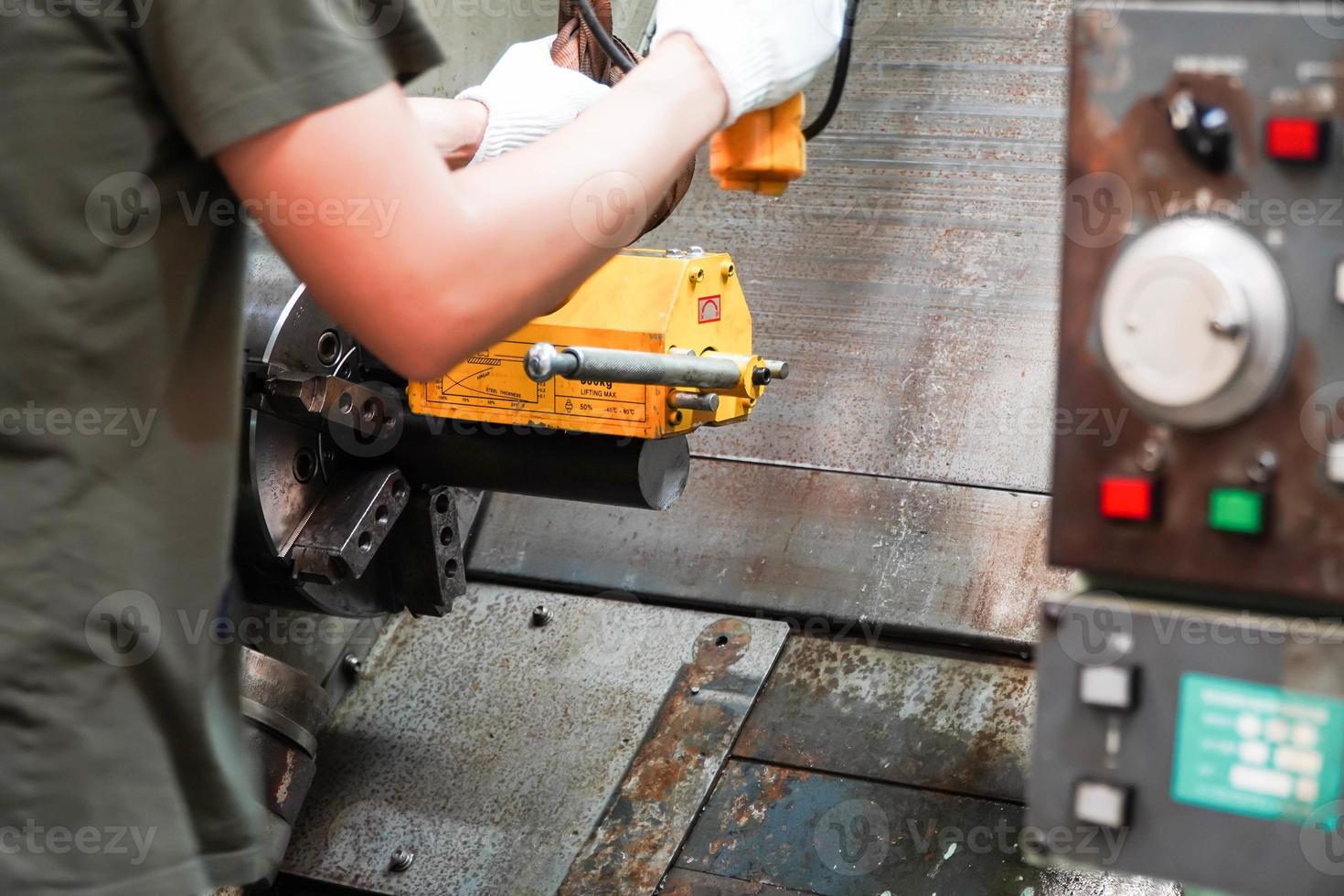 Mit einem Magneten hebt der Mechaniker das Werkstück kontrolliert von Hand an. foto