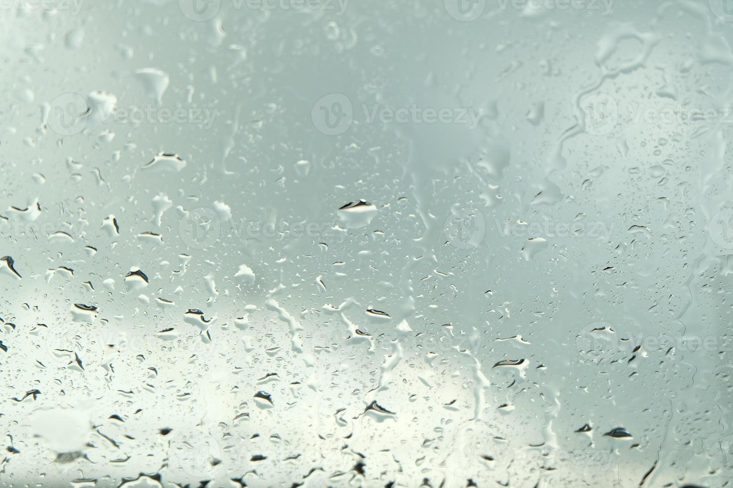 Wassertropfen auf einer Glasoberfläche, weißer Farbverlauf foto