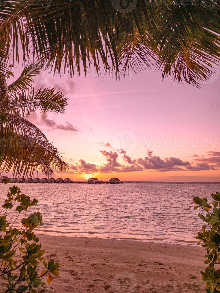 sonnenuntergang auf der malediven-insel. Wunderschöner Sonnenuntergangshimmel und Wolken, luxuriöse Wasservillen und Holzsteg. exotische sommerferien und reisekonzept foto