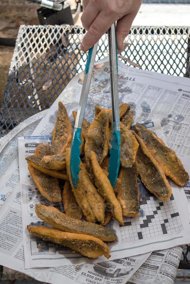 panierte Meerbarbenfilets auf Fischbrötchen auf Zeitungspapier ausgelegt foto