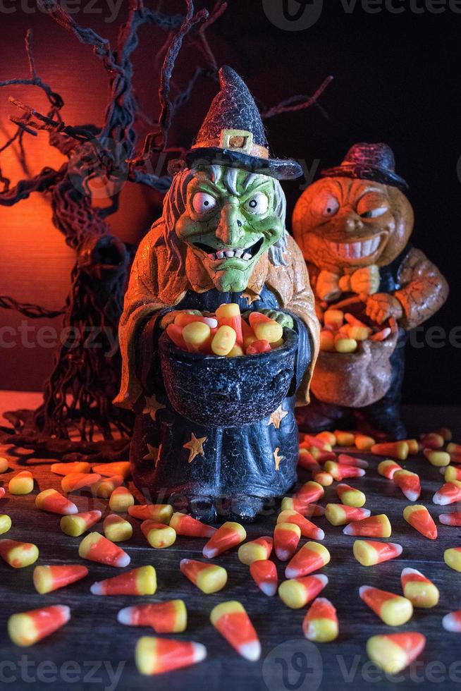 halloween-charaktere im gespenstischen hintergrund, die bonbonmais sammeln foto