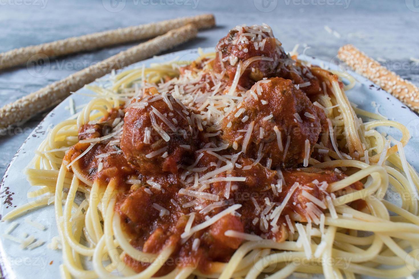 Nahaufnahme von Spaghetti und Frikadellen mit Grissini foto