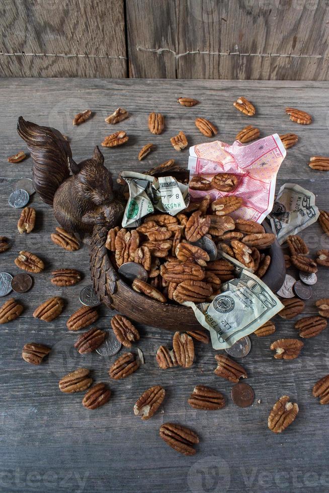 Eichhörnchen mit Schale mit Nüssen und Geld foto