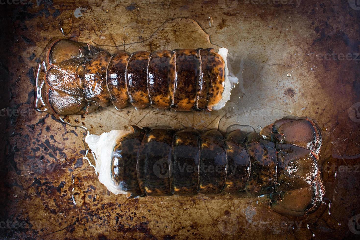 Frische Hummerschwänze auf metallstrukturierter Pfanne von oben foto