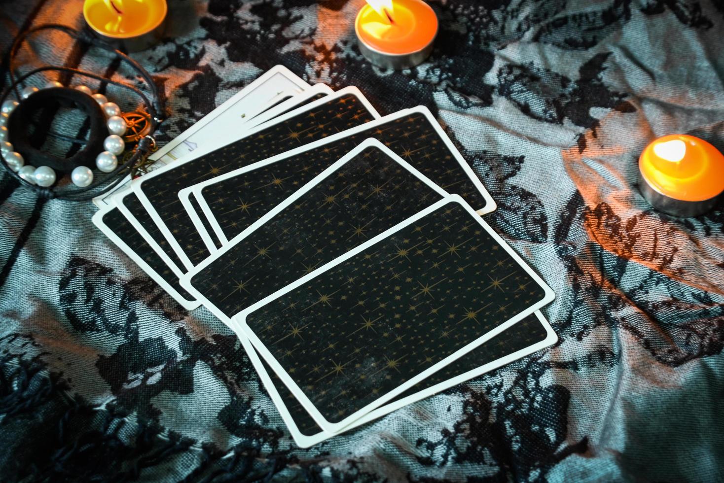 tarotlesung mit tarotkartenhintergrund und kerzenlicht auf dem tisch für astrologie okkulte magische spirituelle horoskope und handlese-wahrsager-tarotleser foto