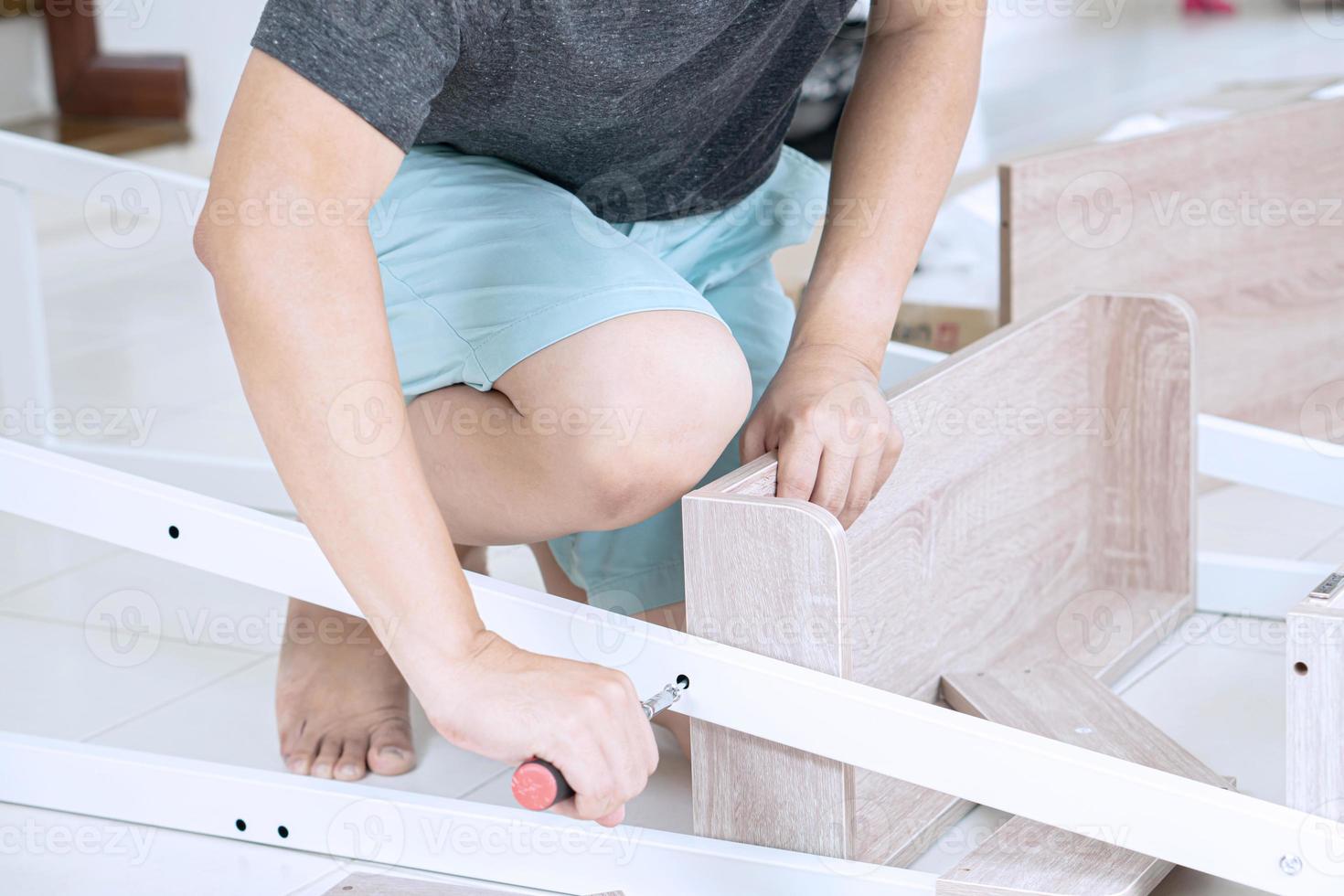 älterer mann, der möbel zu hause zusammenbaut, ein neues wohnkonzept foto