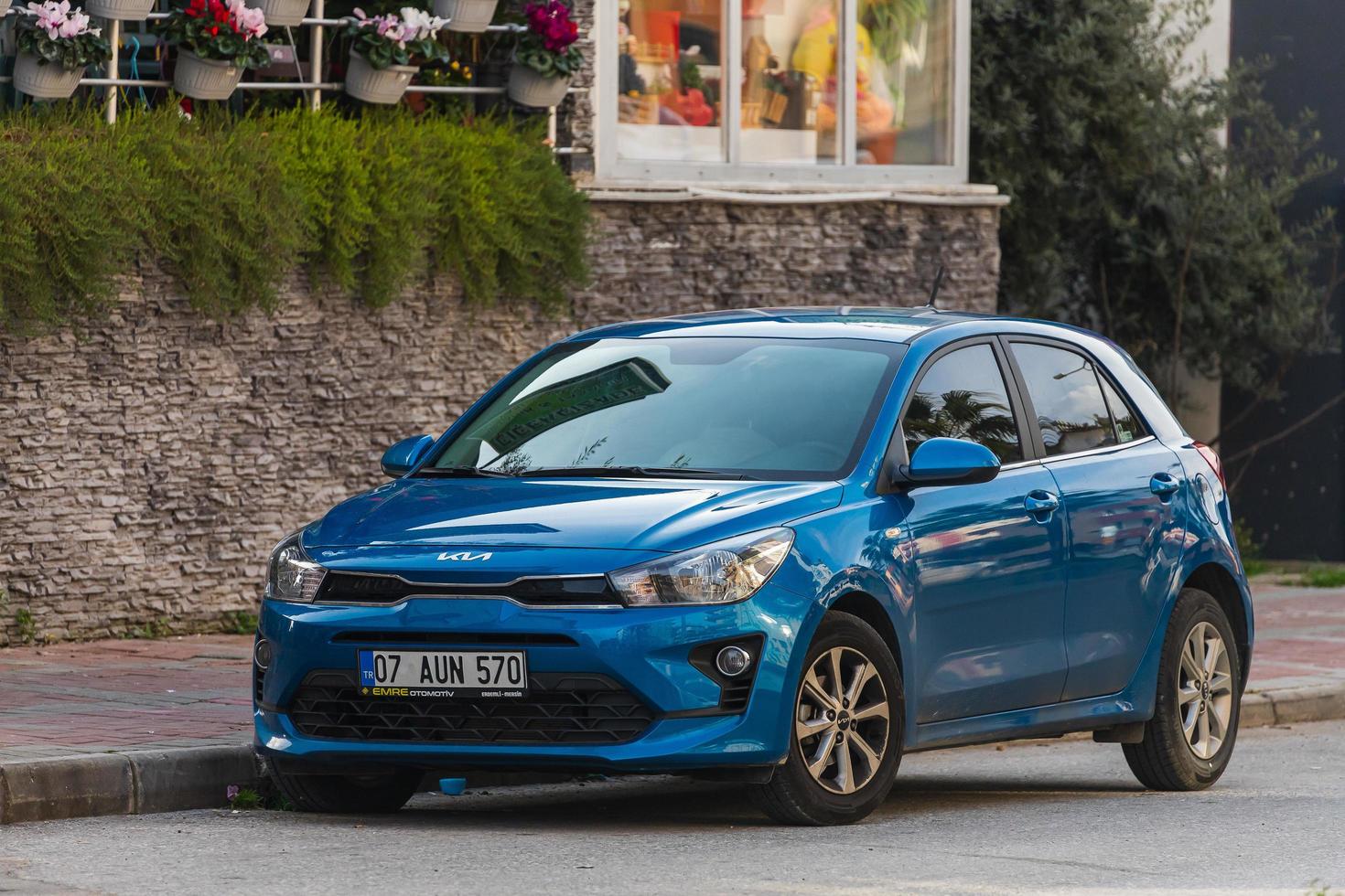 Seitentürkei 03. März 2022 Blue Kia Rio wird an einem warmen Tag vor dem Hintergrund eines Gartens, Zauns auf der Straße geparkt foto