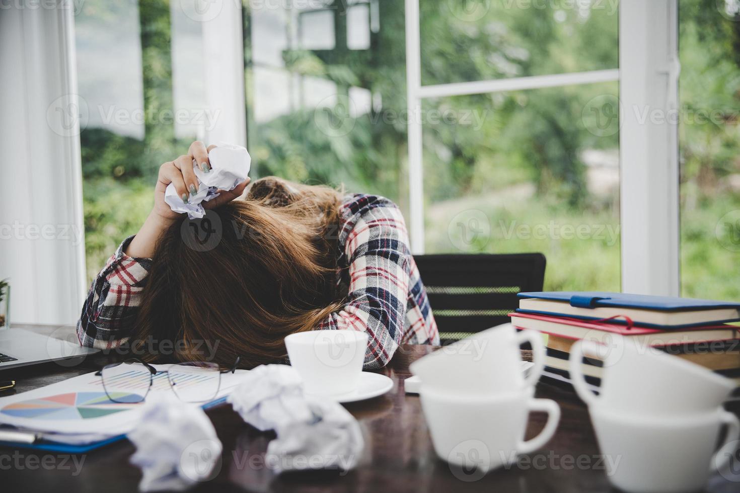 junge frustrierte frau, die im büro arbeitet foto