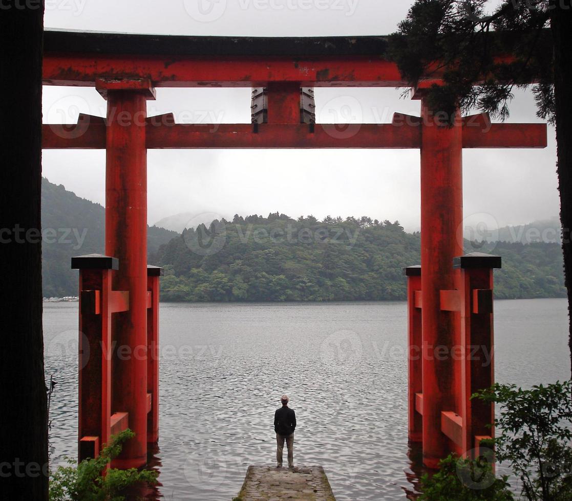 mann, der nahe torii in hakone, japan steht foto