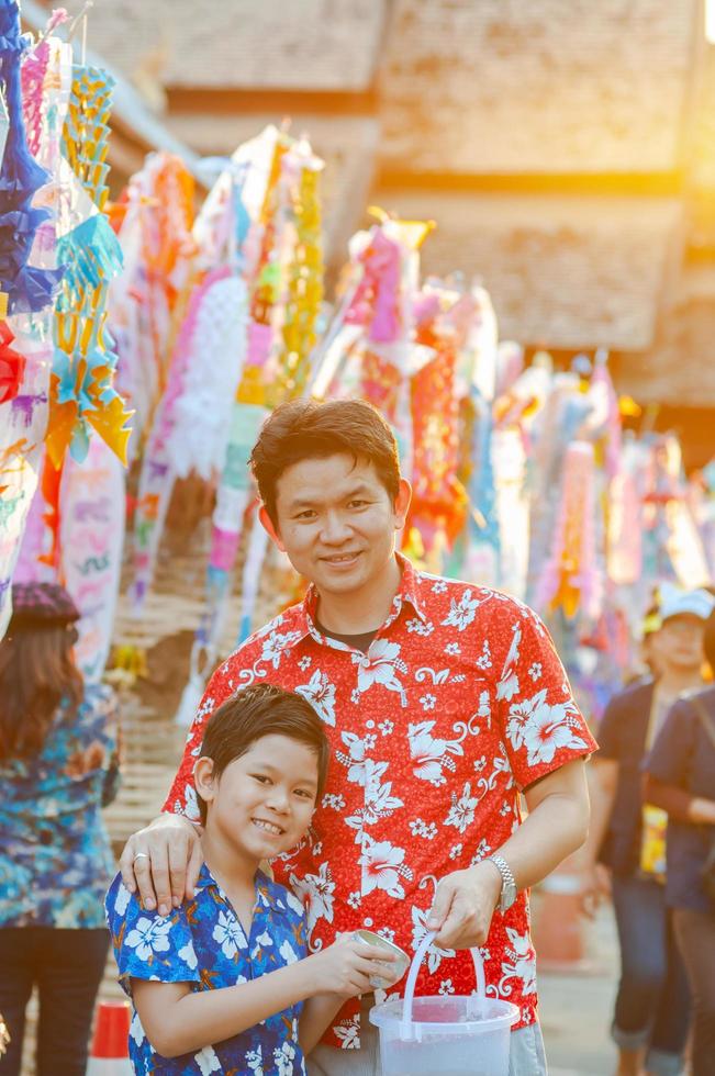 thailändische familie nimmt an alten traditionellen aktivitäten in einem tempel während des songkran-festivals in chiang mai nordthailand teil sehr berühmtes ereignis thailands foto