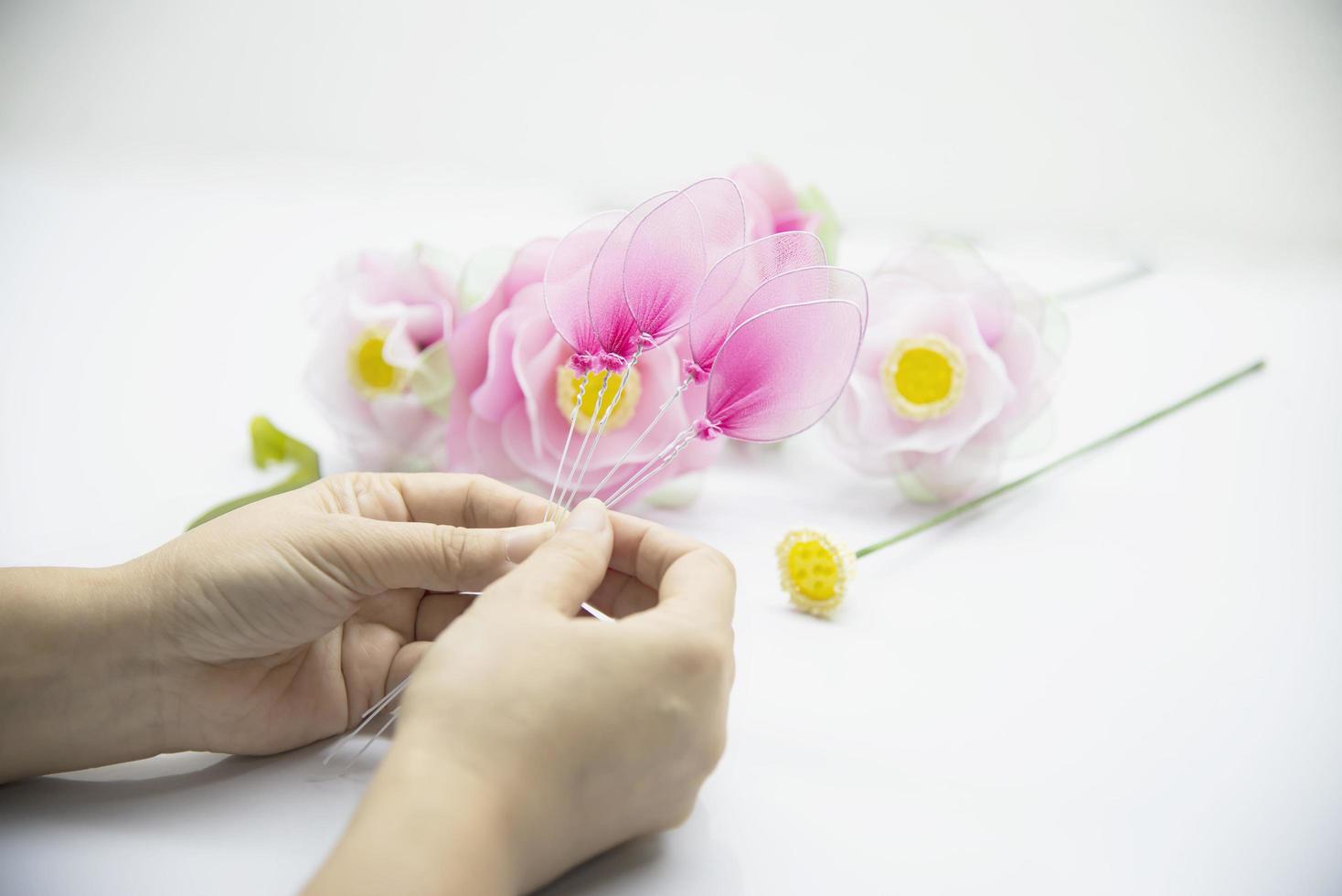 frau, die schöne nylonblume macht - leute mit diy handgemachtem blumenkonzept foto