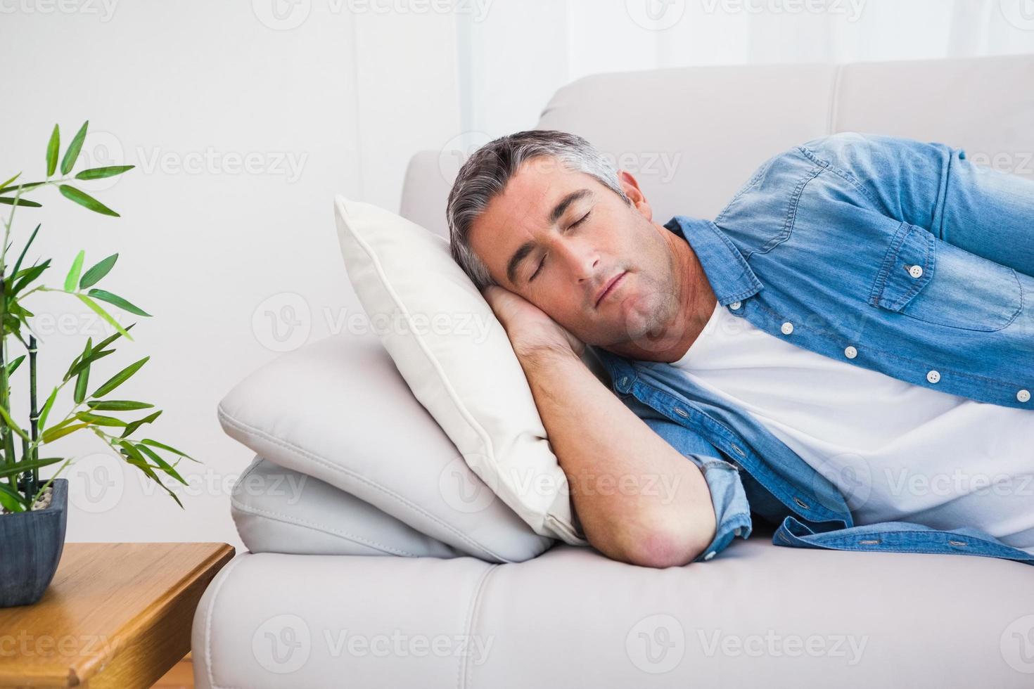Mann mit grauen Haaren, die auf der Couch schlafen foto
