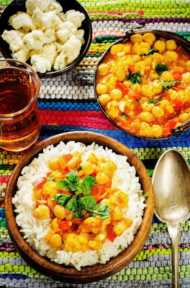 Reis mit Curry-Kichererbsen mit Gemüse und arabischem Fladenbrot mit Kräutern foto