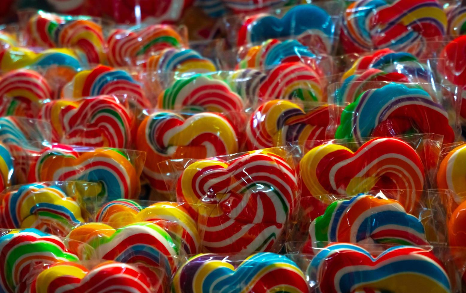 bunte Strudellutscher in Süßwaren. süße Süßigkeiten für Kinderparty. Candy-Day-Konzept. Spiralförmige Lutscher in Regenbogenfarben. ungesundes Essen. Retro-Süßigkeiten für Kinder. handgemachter Strudellutscher. Junk-Food. foto