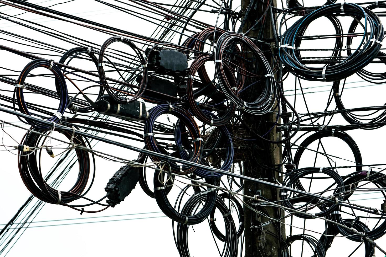 verwirrte elektrische Kabel auf städtischen Strommasten. desorganisiert und chaotisch für das organisationsmanagementkonzept foto