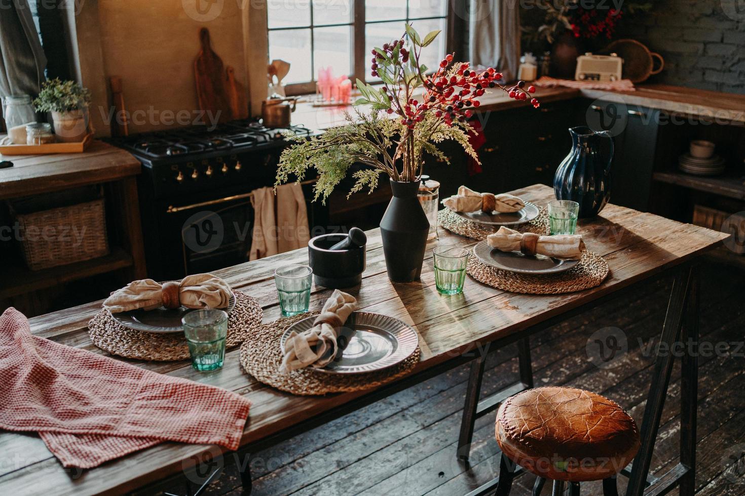 Tisch zum Abendessen serviert. gemütliches kücheninterieur. Besteck und Servietten auf dem Tisch für die Gäste. Familienfrühstück. Essenszeit. keine Leute. foto