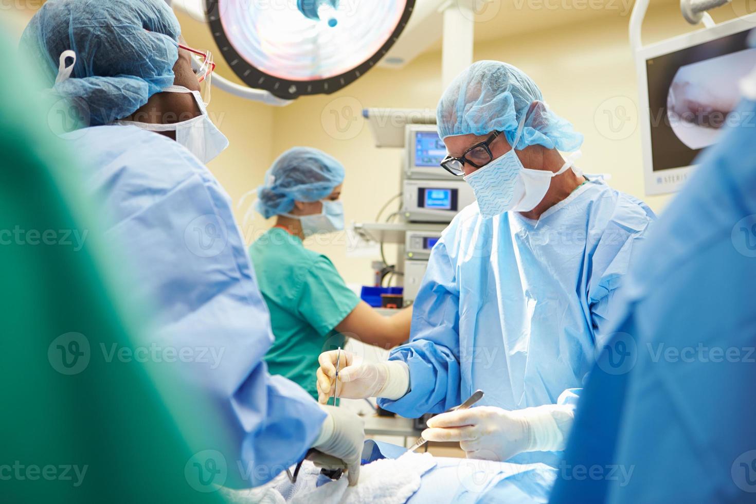 ein Operationsteam, das einen Patienten operiert foto
