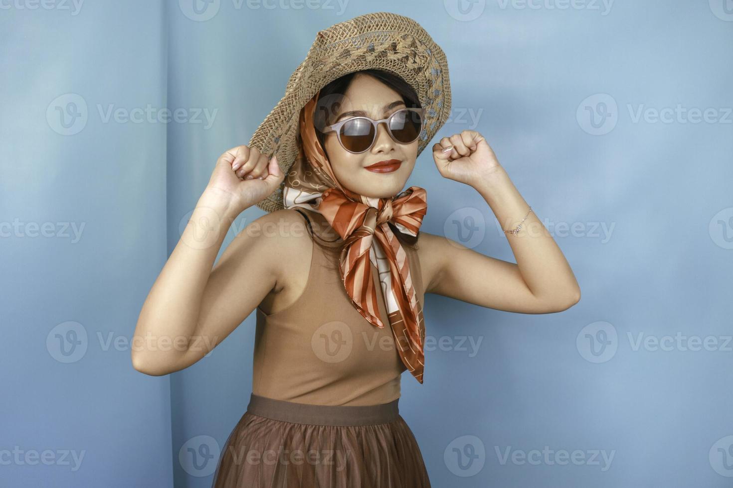 junge asiatische selbstbewusste und glückliche frau, die durch einen blauen hintergrund isoliert wird. foto