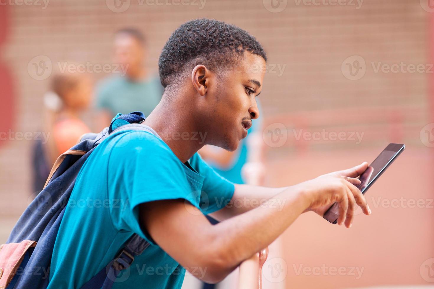 männlicher afrikanischer Student, der Tablet-Computer verwendet foto