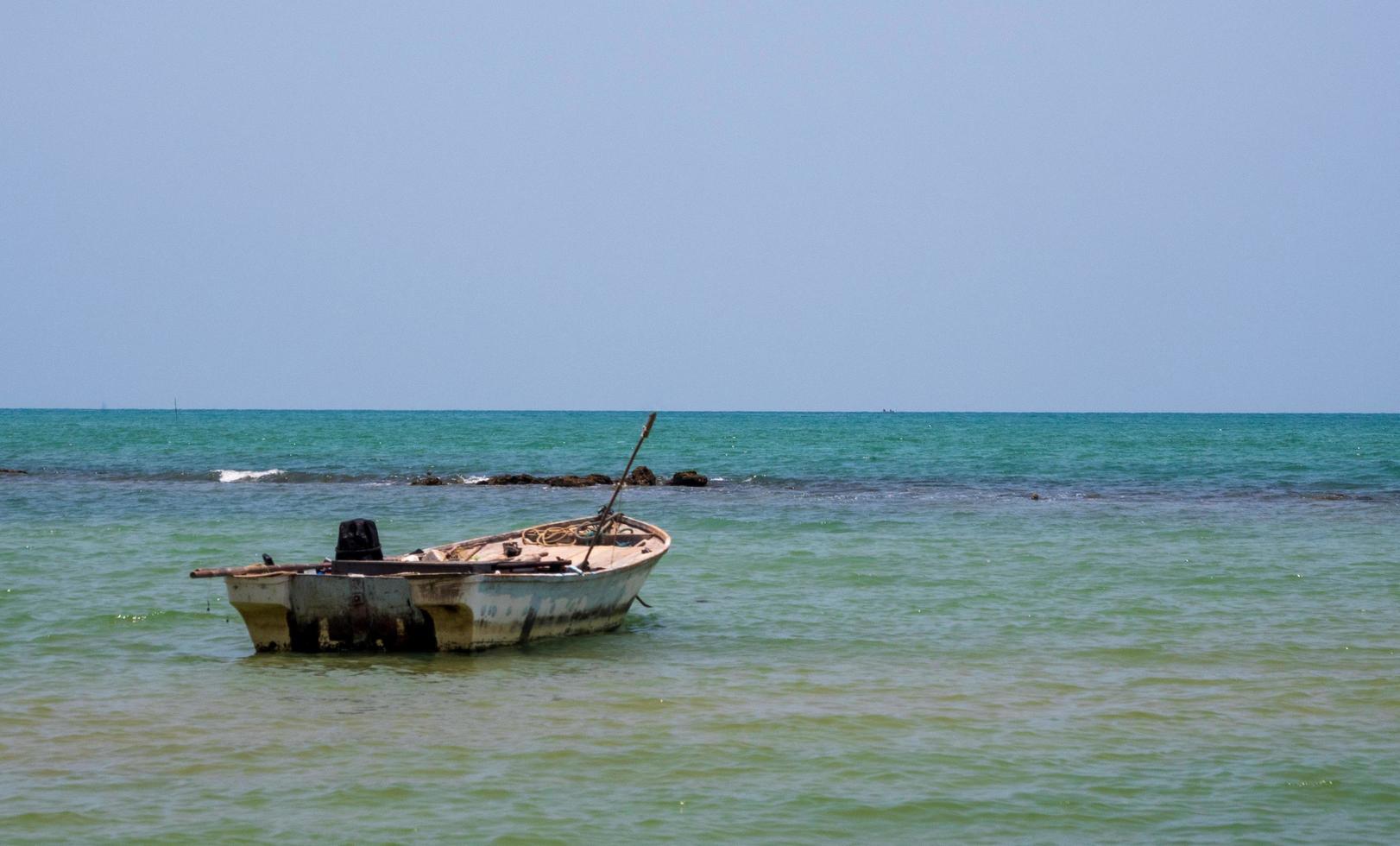 landschaft blick aussicht kleines fischerboot holz alt geparkt küste meer. nach dem fischfang der fischer im kleinen dorf es die kleine lokale fischerei. blauer himmel, weiße wolken, klares wetter, phala beach, rayong foto