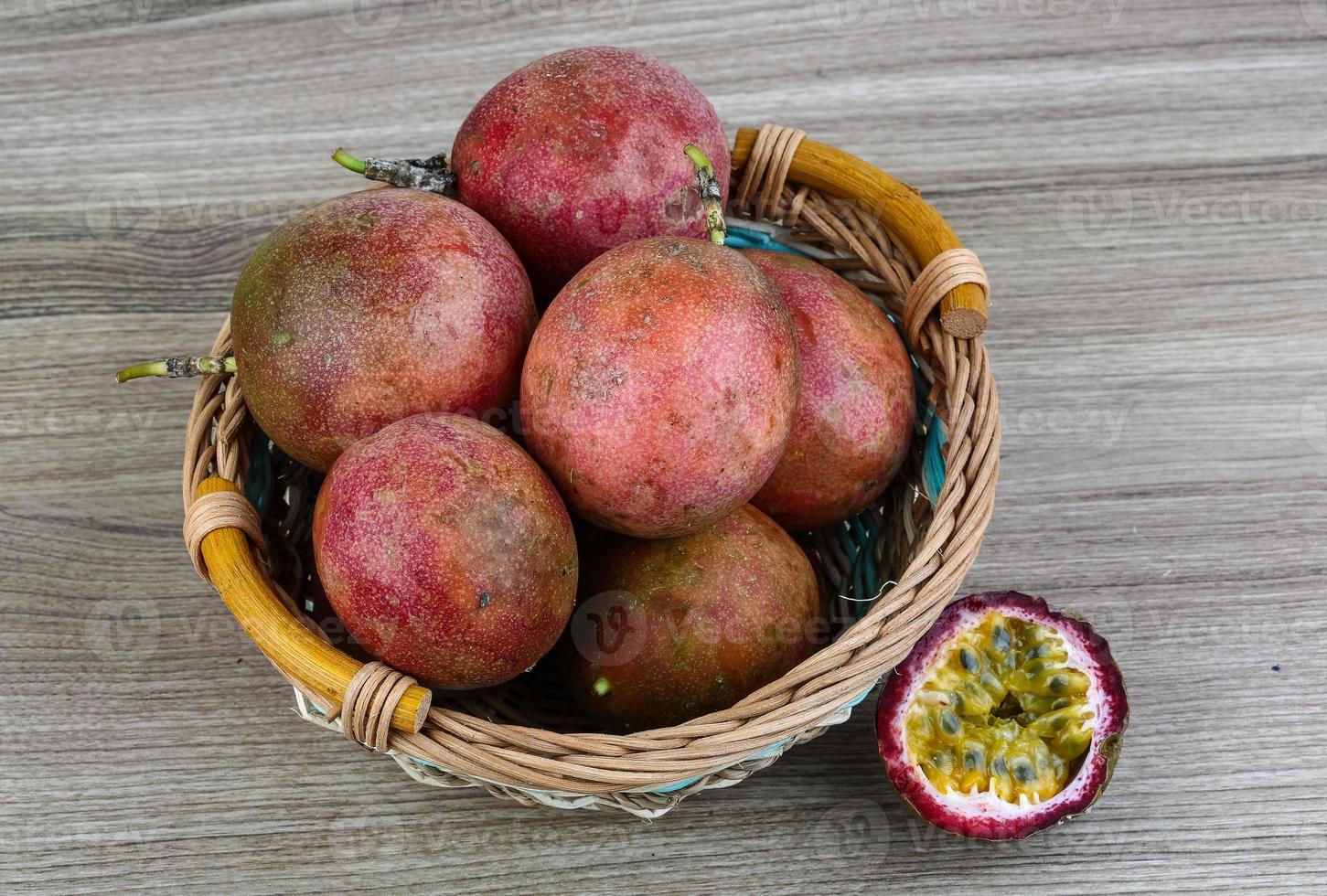 Frische tropische Früchte - Maracuja in einem Korb auf Holzhintergrund foto